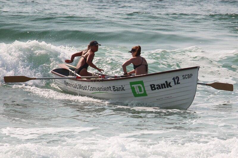 Julia Rothstein rows a boat in the ocean with another lifeguard.