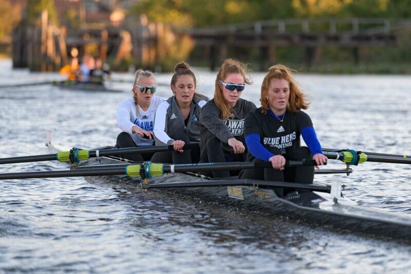 Julia Rothstein row in a river with three of her rowing teammates.